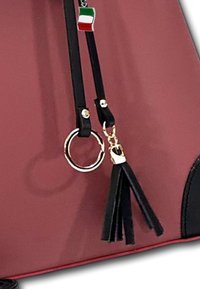 Rode handtas met zwarte banden, gouden hardware, een ronde ring en een kwastaccent. Inclusief een klein Italiaans vlagdetail.