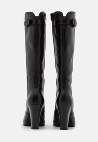 Black knee-high boots made of smooth leather, featuring a curved top, adjustable buckle accents, and high block heels.