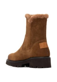 Botas de tobillo de ante marrón con un cuello de piel sintética, puntera redonda, suela de goma negra gruesa y un acento de cuero en la parte trasera.