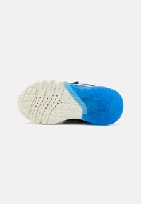 Talpă de sneaker albă și albastră, cu o talpă exterioară texturată albă, având o secțiune de talpă lăcuită și orificii de drenaj.