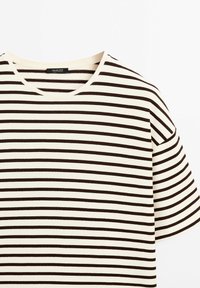 T-shirt blanc à manches courtes avec fines rayures horizontales noires et encolure ronde.