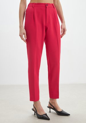 Pantaloni rossi su misura con pieghe, chiusura a bottone e tasche laterali. Il tessuto è liscio e il design a gamba affusolata conferisce eleganza.