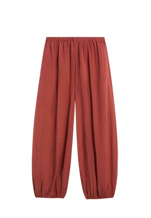 Løse rustfarvede bukser med elastisk taljebånd og elastiske manchetter ved anklerne, lavet af letvægtsstof.