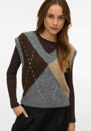 Grijs, bruin en beige gebreid vest met een ruitpatroon, pluizige textuur, brede armgaten en zichtbare steekdetails, over een donker shirt gedragen.