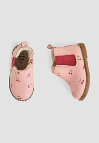 Botas de cuero rosa hasta el tobillo con estampado de cerezas, panel lateral elástico y forro suave. Suela de goma marrón, diseñadas para la comodidad y facilidad de uso.