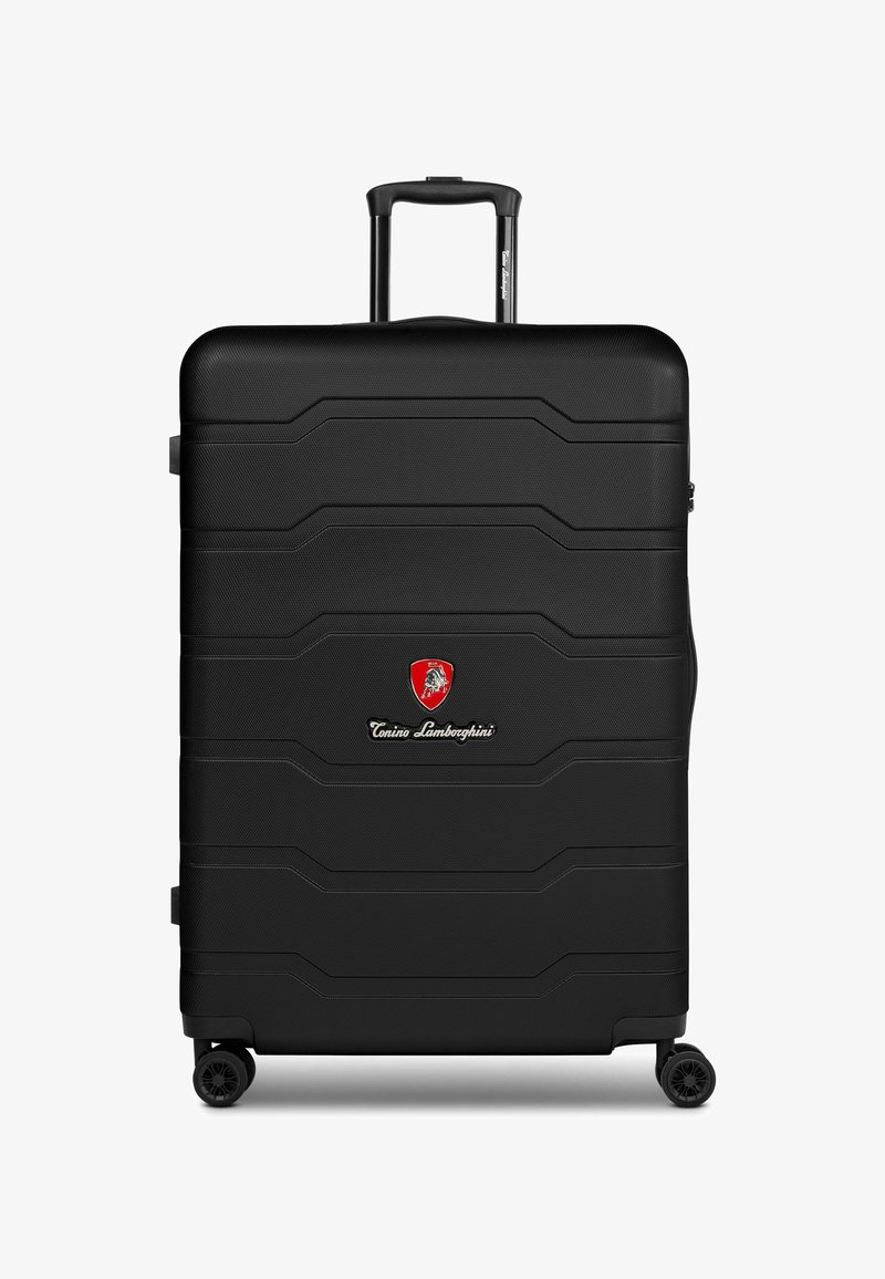 Valise rigide noire avec surface texturée, dotée de lignes en relief, d'une poignée supérieure, d'une poignée rétractable et de quatre roues pour la mobilité.