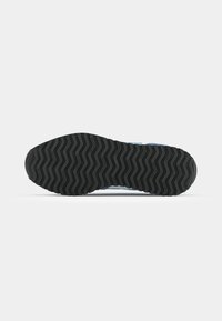 Black rubber outsole featuring a wavy tread pattern, with blue accents on the sides. Smooth surface with a flexible design for traction.