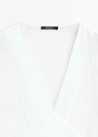 Weiße, strukturierte V-Ausschnitt-Bluse mit Wickeldesign und einem Massimo Dutti Etikett am Halsausschnitt.