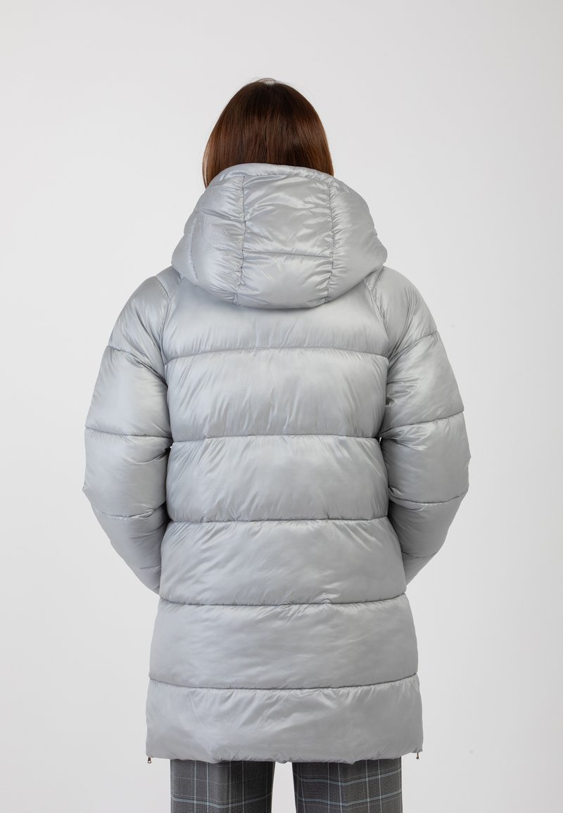 Cappotto puffer grigio con cappuccio, caratterizzato da un design trapuntato e una texture lucida e liscia. Tasche con zip ai lati.