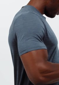 Camisa de hombre de manga corta en gris oscuro, fabricada en un tejido ligero y texturizado. Cuenta con un escote redondeado y una silueta ajustada.