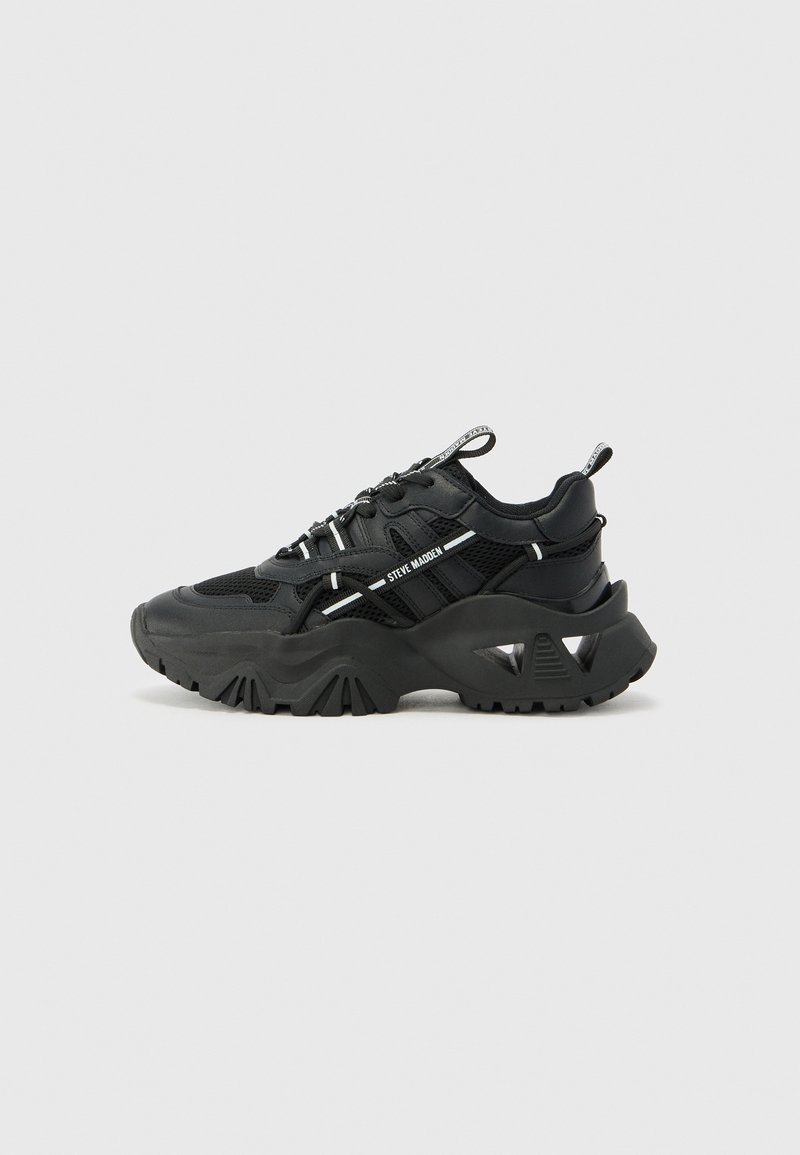 Zwarte sneakers met een bovenkant van mesh en synthetisch materiaal, een ronde neus, dikke zool en reflecterende accenten. De zool heeft een uitgesproken profiel.
