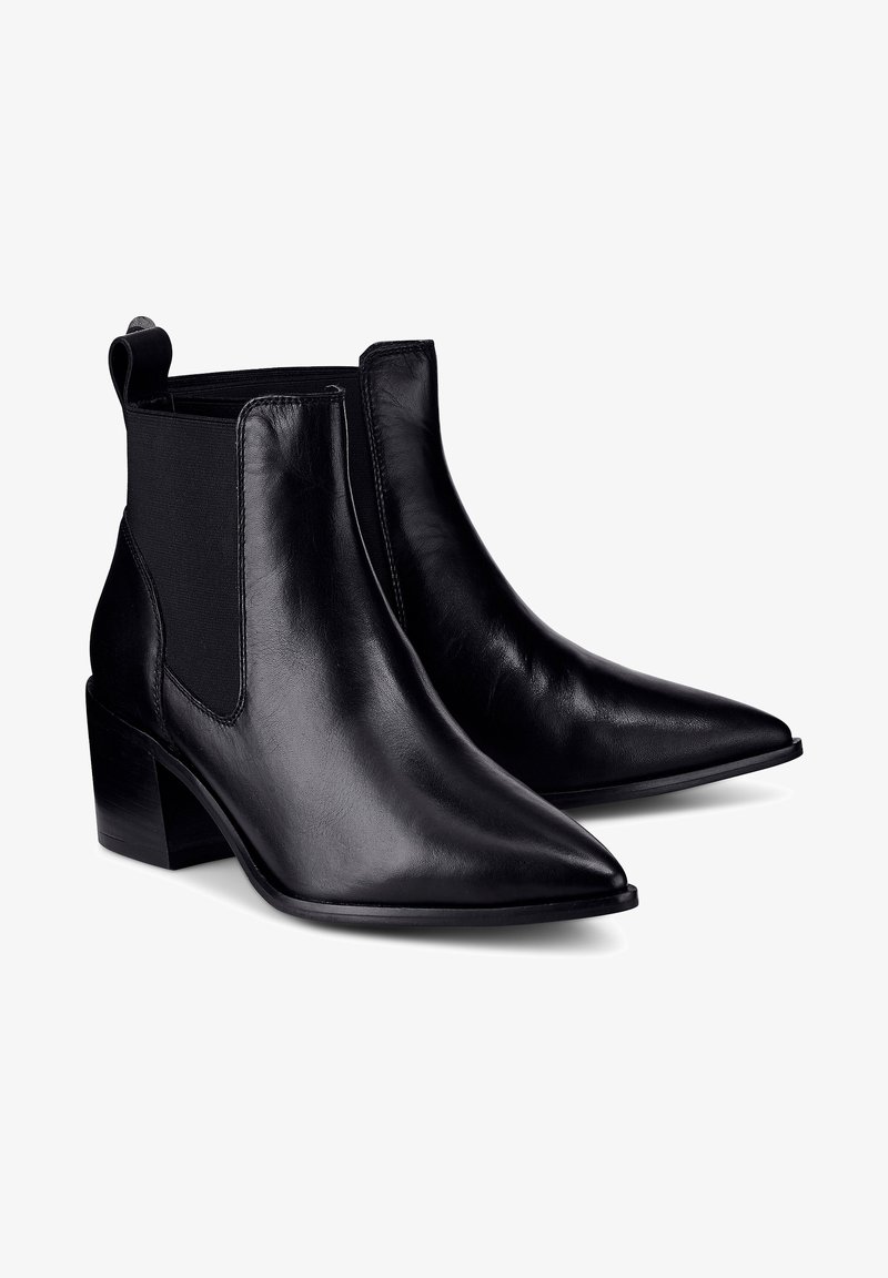Bottines en cuir noir à bouts pointus, panneaux latéraux élastiques et talons blocs sur fond blanc.