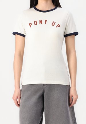 Camiseta de manga corta color crema con cuello y puños azul marino; presenta texto rojo "PONY UP" en diseño curvo.