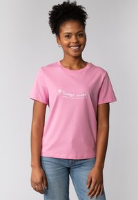 Roze katoenen T-shirt met korte mouwen en een ronde hals, met de witte tekst "Finger weg!" op de voorkant. Gladde textuur en een casual pasvorm.