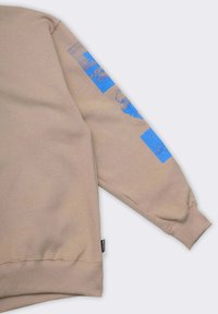 Felpa beige a maniche lunghe; design grafico blu sulla manica destra; polsini e orlo a coste; morbido tessuto.