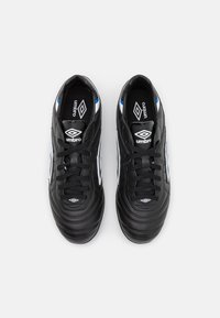 Black soccer cleats with a textured synthetic upper, featuring white and blue accents, laces, and the Umbro logo on the tongue.