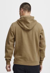 Brown fleece hoodie with kangaroo pocket and adjustable drawstring hood. Ribbed cuffs and hem, smooth texture, and relaxed fit.