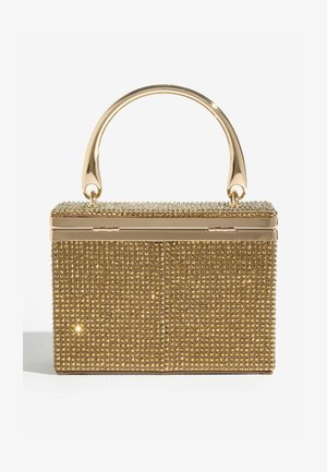 Złota torebka w kształcie pudełka z kryształowymi zdobieniami, zaokrągloną złotą rączką i gładką teksturą. Z przodu znajduje się zapięcie na zawias.