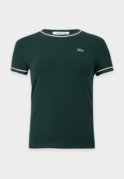 T-shirt vert foncé à manches courtes avec finition blanche sur le col et les manches, avec un petit logo crocodile sur la poitrine gauche.