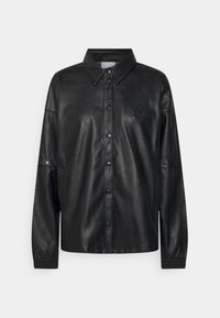 Svart läder skjortjacka med spetsig krage, framtida tryckknappar, elastiska ärmar och en liten präglad logotyp på bröstet.