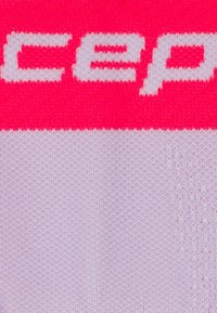 Primo piano di un tessuto lavorato a maglia in rosa e bianco con testo bianco parziale "cep" sulla sezione rosa.