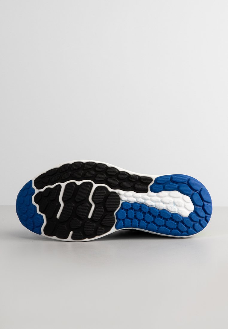 Suela de zapato de running con una base de goma negra texturizada y acentos en azul y blanco, que muestra un patrón de panal para mayor agarre.