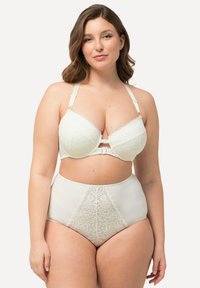 Licht crèmekleurig kant beha met gewatteerde cups, decoratieve stiksels en verstelbare bandjes. Hoge taille slip met kantpaneel aan de voorkant.