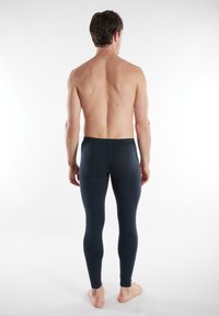 Leggings blu scuro realizzati in tessuto elastico, design aderente e texture liscia. La vita è elastica e l'orlo è rifinito.