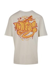 Beige bomulds T-shirt med et livligt orange og rødt graffiti-stil design på ryggen, med svungne tekster og dekorative accenter.