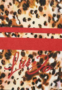 Tessuto leopardato con macchie beige, marroni e nere. Due righe orizzontali rosse solide. Testo "Live Jo" in calligrafia rossa. Texture morbida.
