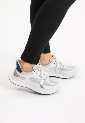 Weiße und silberne Sportschuhe mit Mesh-Einsätzen, runder Spitze und gepolsterter Sohle. Mit grauen Akzenten und traditionellem Schnürsystem.