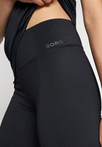 Juodos aukšto liemens legging'os pagamintos iš elastingos medžiagos, su BORG logotipu ant juosmens ir sustiprintomis siūlėmis, kad būtų užtikrintas ilgaamžiškumas.