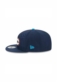 Casquette de baseball bleu marine à visière plate, avec un logo imposant en orange et blanc, agrémentée d'un accent turquoise à l'arrière et sur le bouton.