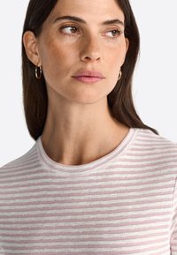 Light pink striped short-sleeve shirt with metallic threads, round neck, smooth texture, and subtle shimmer effect.