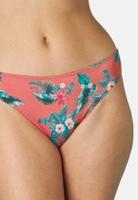 Parte inferiore del bikini corallo con motivo floreale, caratterizzato da foglie turchesi e fiori rosa. Realizzato in un tessuto elastico con una texture liscia.