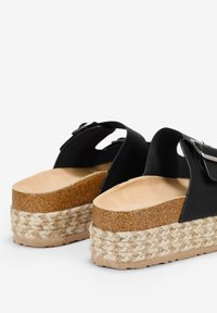 Sandales à plateforme noires avec une large bride, semelle en liège avec des détails en jute et une finition texturée sur la bride pour une meilleure adhérence.