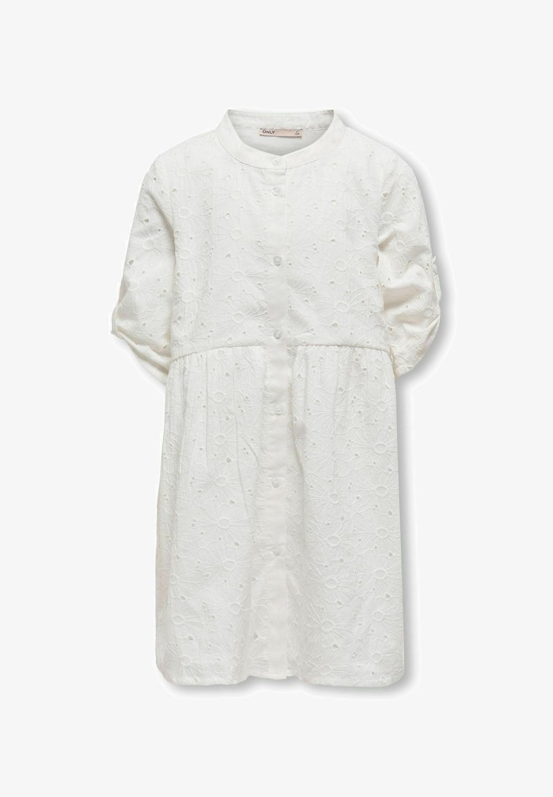 Valge puuvillane särgikleit ümmarguse krae, ettepool nuppudega ja lühikeste puhvpea varrukatega. Omab lillelist tikandit ja lõdva istuvusega.