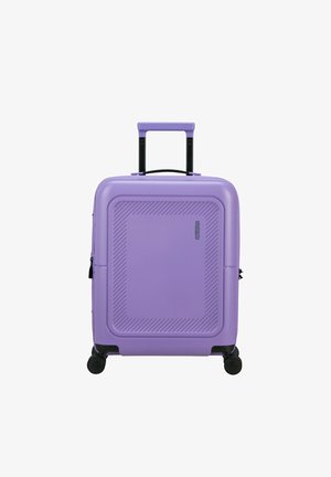 Valigia rigida viola con superficie texturizzata, manico estraibile e quattro ruote nere. Presenta linee diagonali sulla parte anteriore.