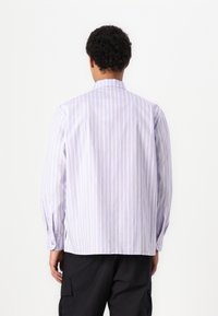 Light purple and yellow striped long-sleeve shirt, featuring a pointed collar and buttoned cuffs. Cotton material with a smooth texture.