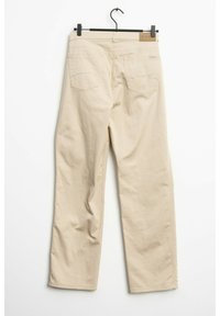 Pantalones beige de pierna recta hechos de algodón. Presentan dos bolsillos traseros y una etiqueta en la cinturilla. Textura suave con un mínimo de detalles.