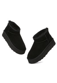 Schwarze Ankle Boots aus Wildleder mit einem weichen Innenfutter. Sie verfügen über eine abgerundete Zehenpartie, eine niedrige Schafthöhe und eine strukturierte Gummisohle.