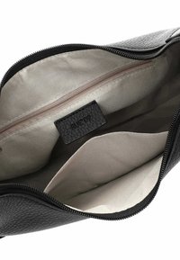 Interno di una borsa in pelle nera con texture, foderato in grigio chiaro. Dotata di una tasca con cerniera e di un'etichetta del marchio "RUE 09". Design aperto e spazioso.