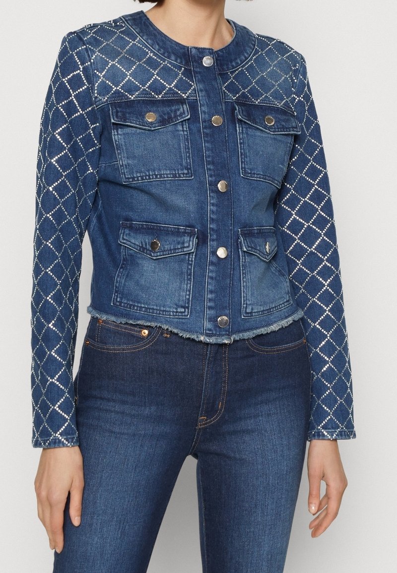 Jeansjakke med en cropped design, prydet med et diamantmønster på ærmerne, med knaplukninger og to frontlommer. Mørkeblå farve.