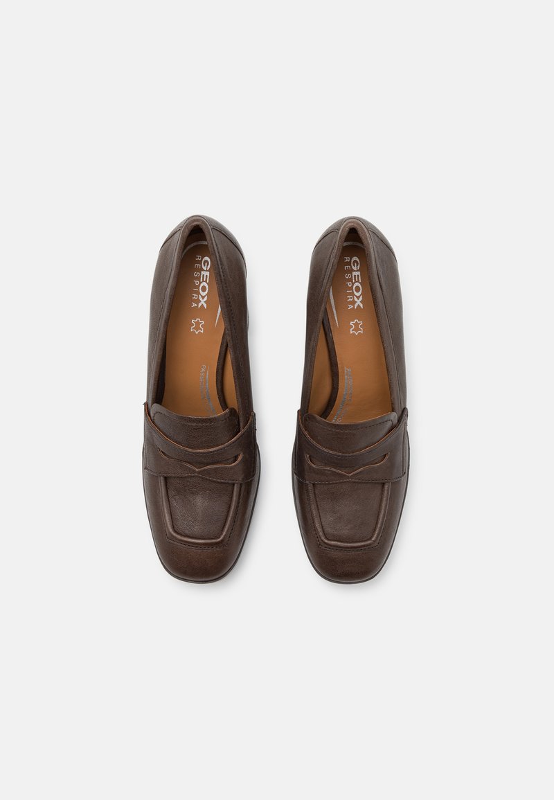 Mocassins en cuir marron avec un embout carré, présentant des accents cousus et une texture lisse. L'intérieur est beige, avec un logo de marque visible.