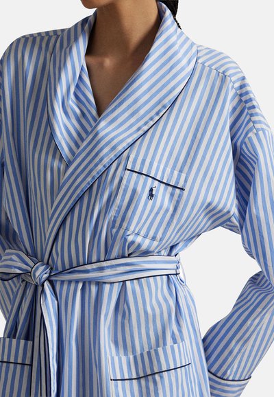 Ριγέ μπουρνούζι σε ανοιχτό γαλάζιο και λευκό, με γιακά σάλι, ζώνη δέσιμου, τσέπη και αντίθετη μαύρη επένδυση κατά μήκος των ακρών.