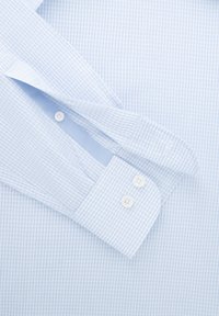 Chemise habillée à carreaux bleu clair avec une texture lisse, dotée de boutons blancs et d'un col standard avec des poignets arrondis.