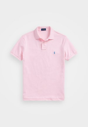 Lys rosa polo skjorte laget av bomull, med en knappestolpe med to knapper, korte ermer, og en liten blå brodert logo på brystet.