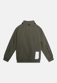 Sweatshirt à manches longues olive avec col haut et boutons-pression noirs, texte "ESPACE POUR TOUS" sur la manche, et écusson à motif carré blanc près de l'ourlet.
