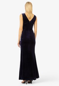 Samtmatter maxi Kleid in Marineblau mit V-Ausschnitt, taillierter Oberteil und fließendem Rock. Verfügt über einen dezenten Glanz und ein minimalistisches Design.