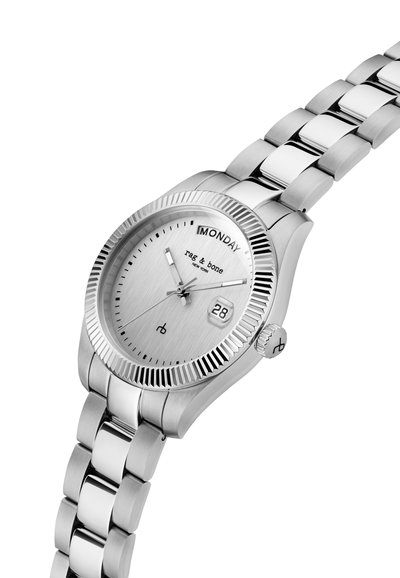 Srebrni ručni sat od nehrđajućeg čelika s prikazom dana i datuma, brušenim brojčanikom i povezanim narukvicom.